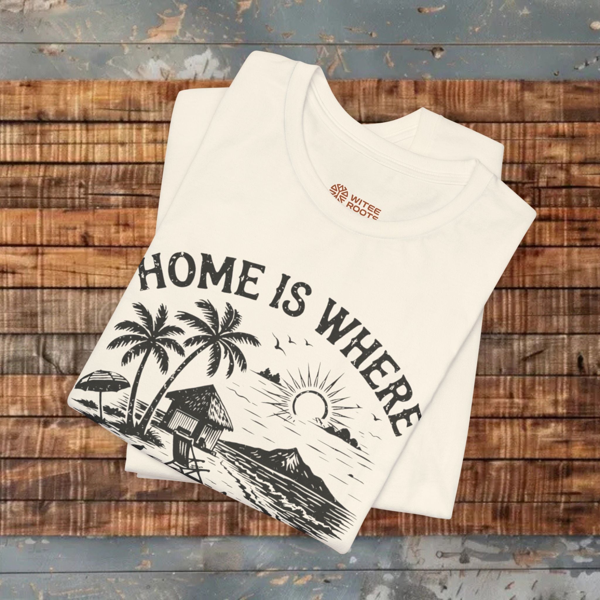 Stack of beige t-shirts with a graphic design and text on a wooden surface