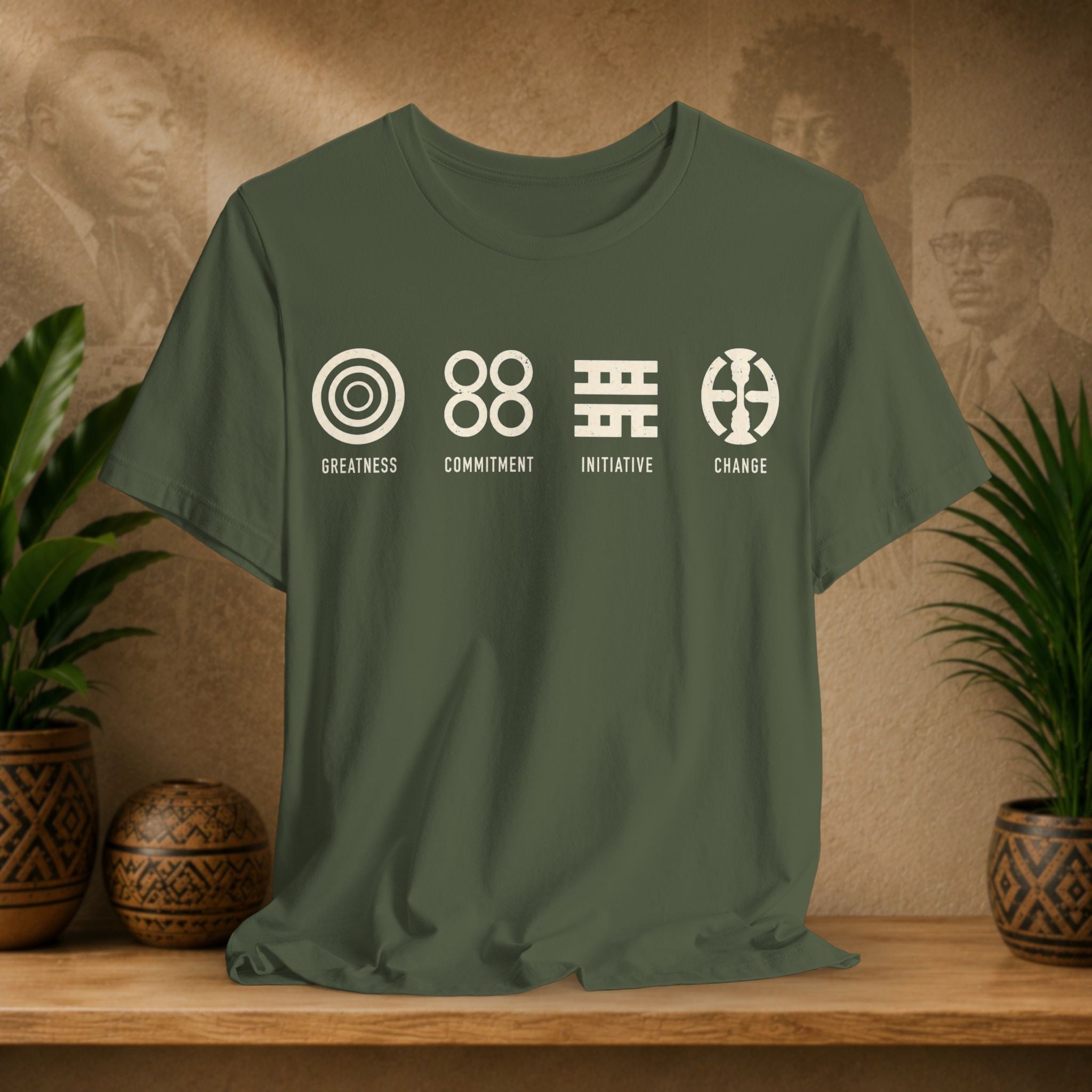 Green t-shirt with white graphics and text on a wooden surface with plants and a textured wall background