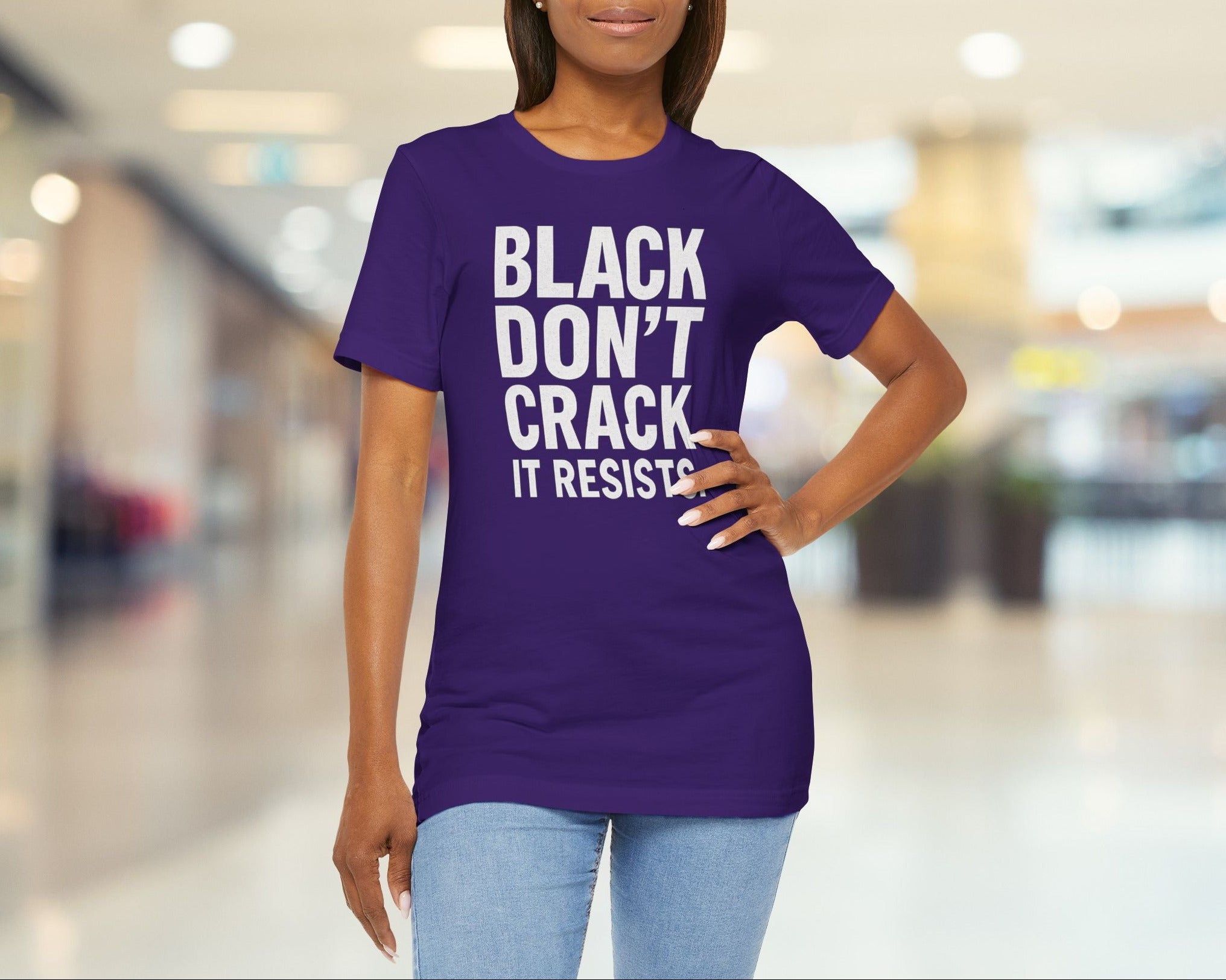 Woman wearing a purple t-shirt with text in a blurred indoor setting