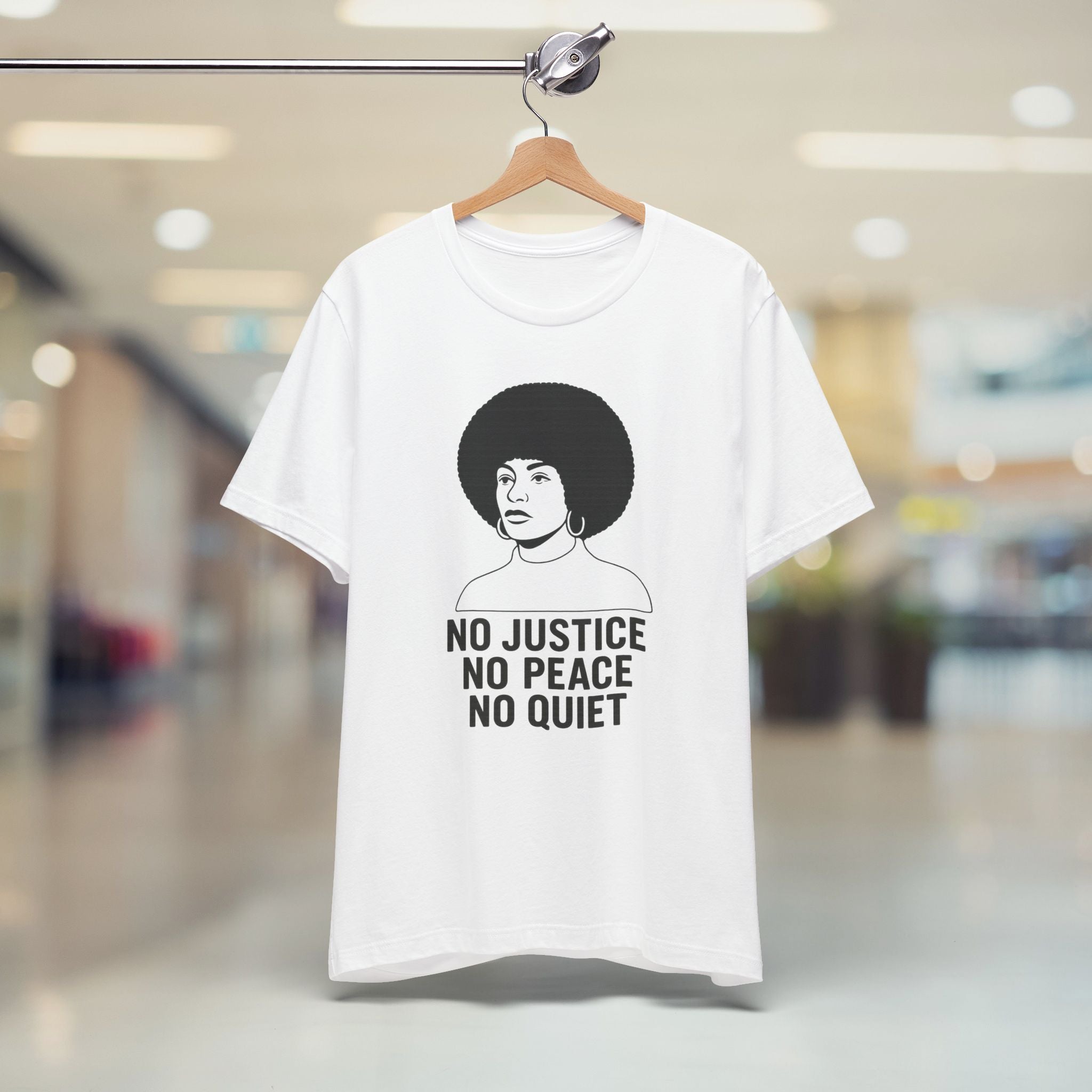 White t-shirt with graphic and text on a hanger in a store setting