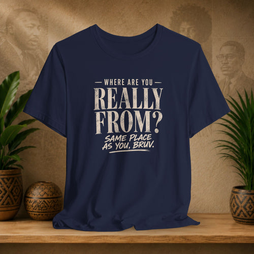 Navy blue t-shirt with humorous text design on a wooden surface with plants and a vintage-style portrait in the background.