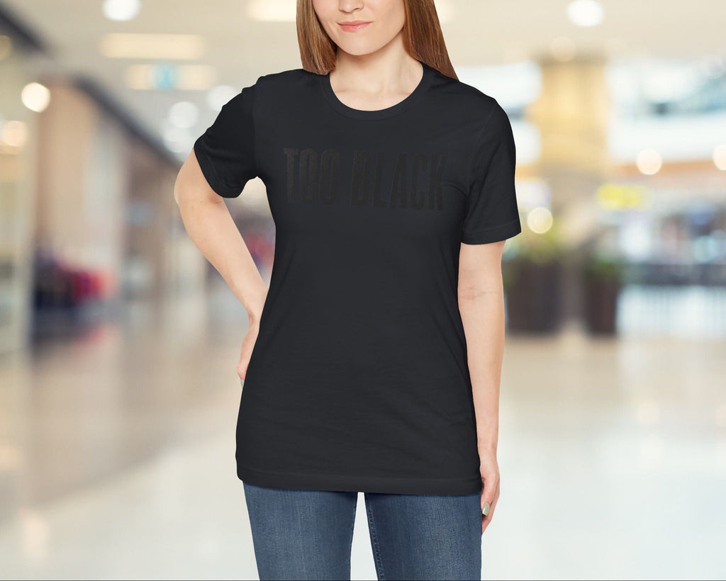 Woman wearing a vintage black t-shirt with text in a blurred indoor setting