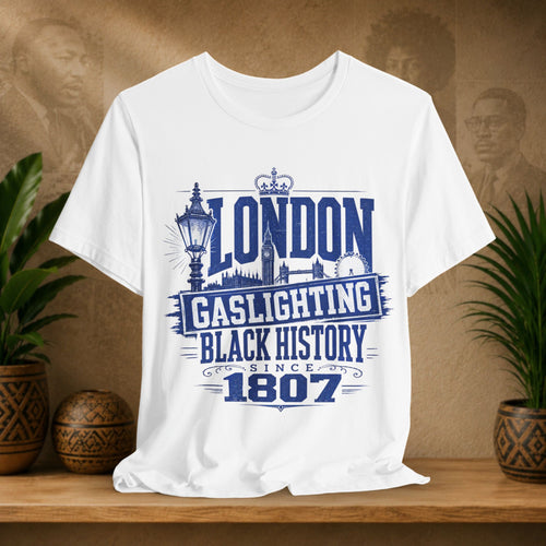 White t-shirt with blue text and graphics on a wooden surface with plants and a brown background