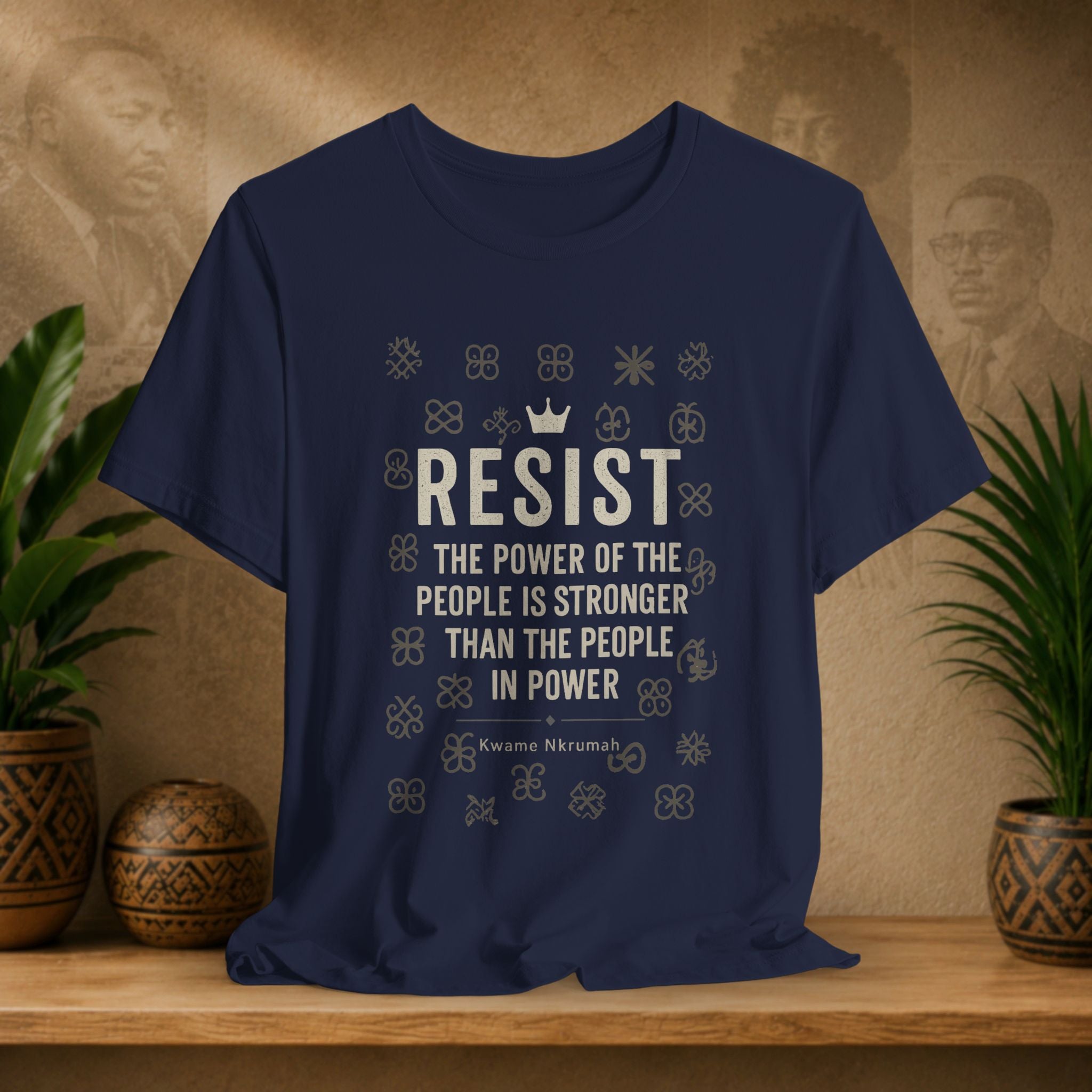 Navy blue t-shirt with motivational quote on a wooden surface with plants and a textured wall background