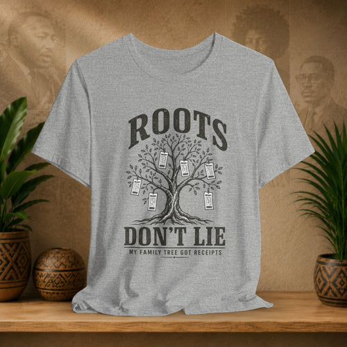 Gray t-shirt with family tree graphic and text on a wooden shelf with plants and decorative items.