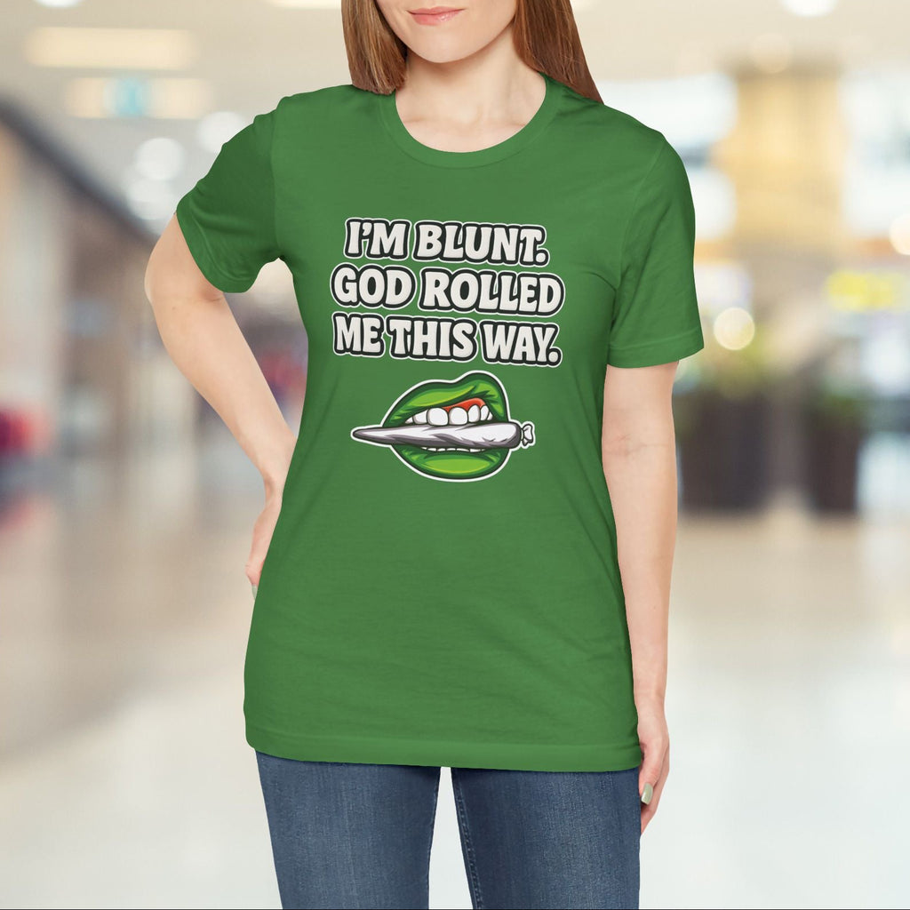 Person wearing a green t-shirt with a graphic and text in a blurred indoor setting