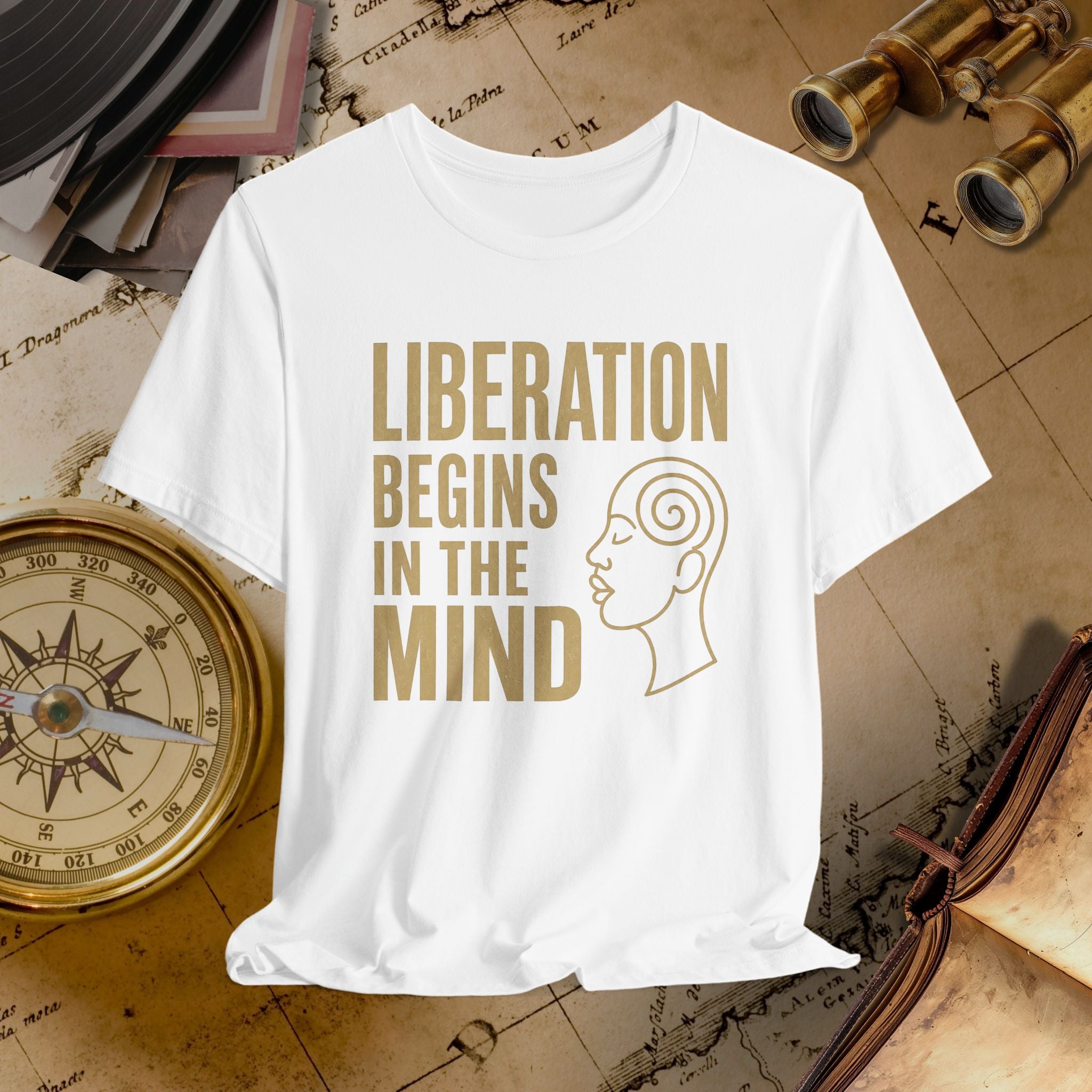 White t-shirt with 'Liberation Begins in the Mind' text and a face outline on a vintage map background.