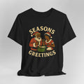 Black t-shirt with 'Seasons Greetings' graphic featuring two people in Santa hats on a gray background
