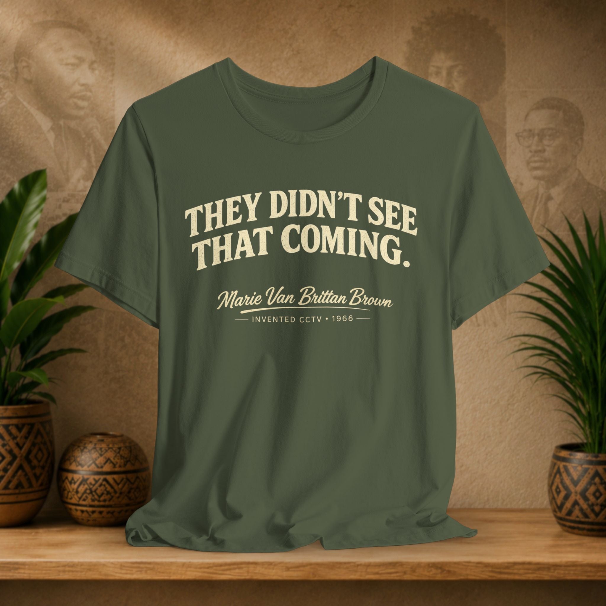 Green t-shirt with text on a wooden surface with plants and a decorative wall in the background