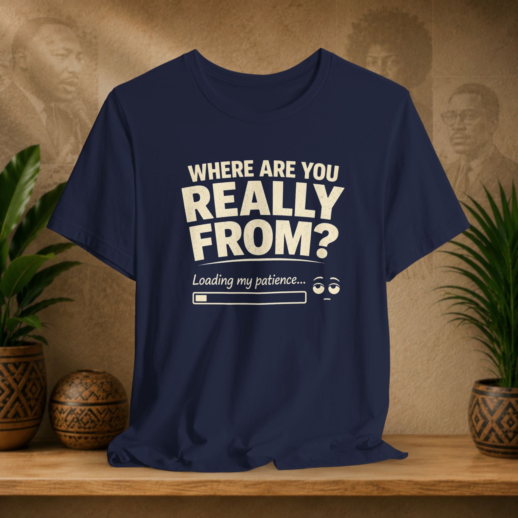 Navy t-shirt with humorous text design on a wooden surface with plants and a textured wall background