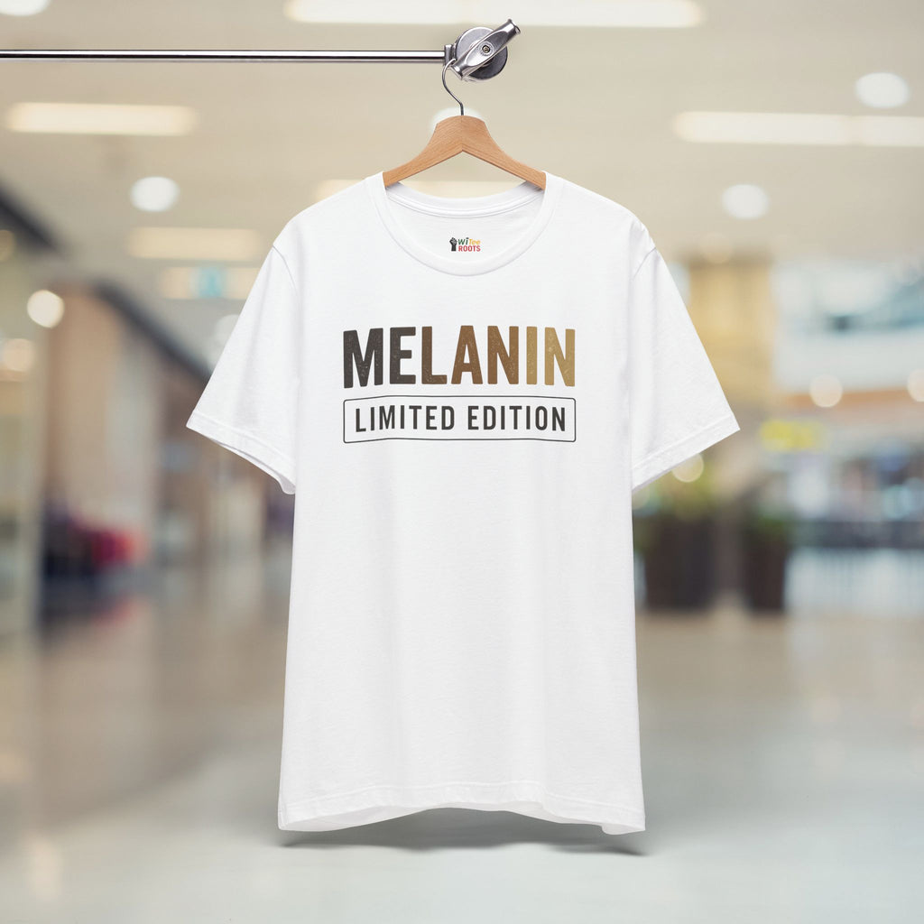 White t-shirt with 'MELANIN LIMITED EDITION' text on a hanger in a blurred indoor setting