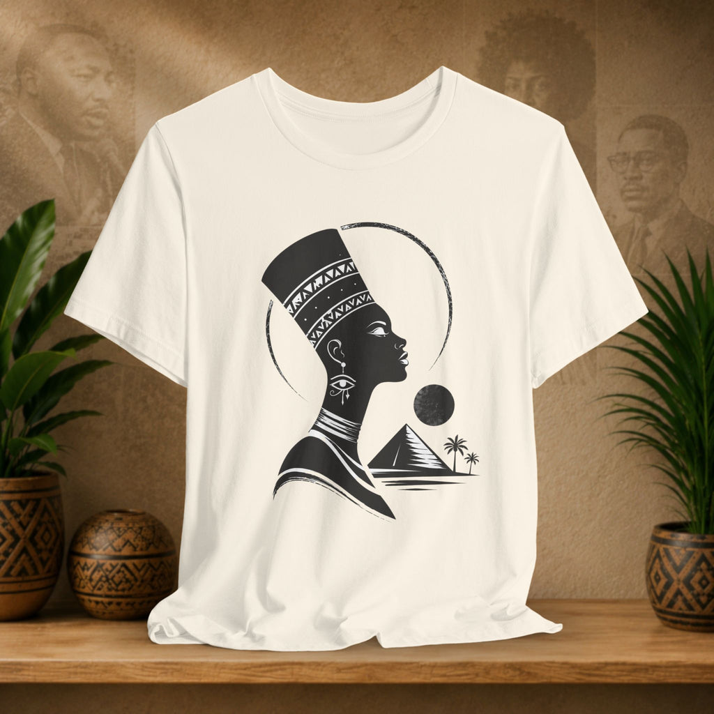 Beige t-shirt with a black silhouette design of a woman with a headdress on a wooden shelf.