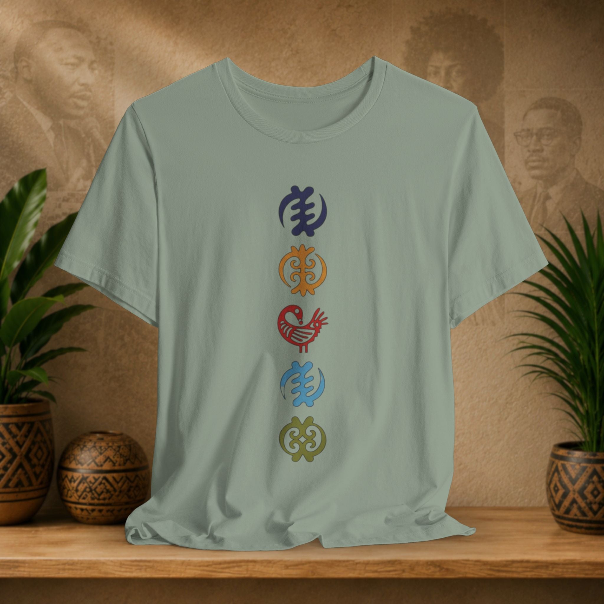 Light green t-shirt with colorful symbols on a wooden surface with decorative plants and background.