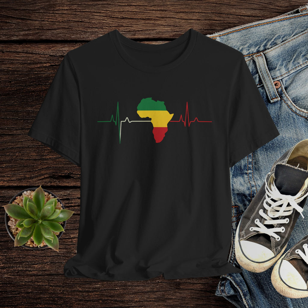 Black t-shirt with a colorful Africa map design on a wooden surface with jeans and sneakers.