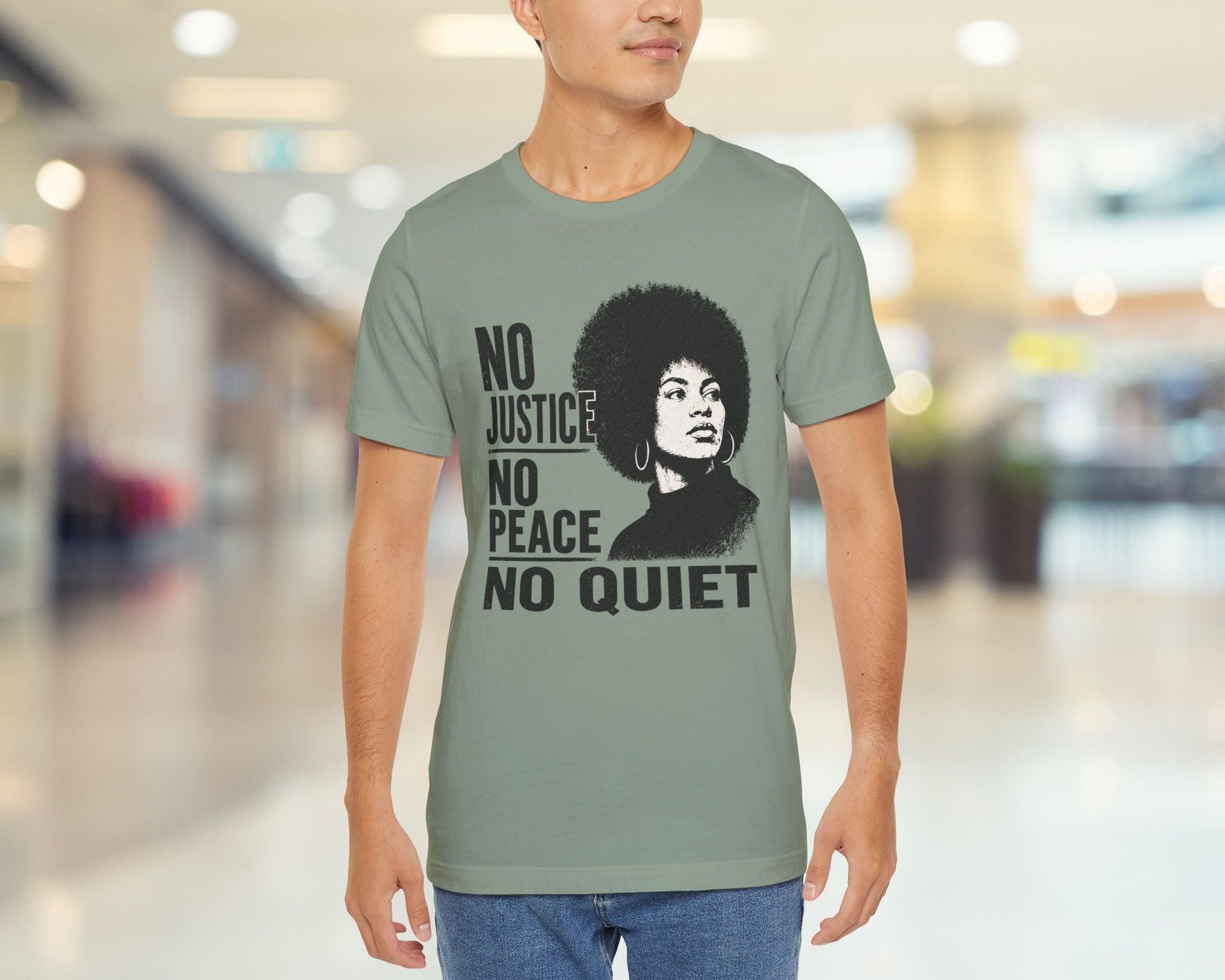 Person wearing a t-shirt with a graphic and text in a blurred indoor setting