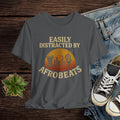 Gray t-shirt with 'Easily Distracted by AfroBeats' design on a wooden surface with jeans and sneakers.