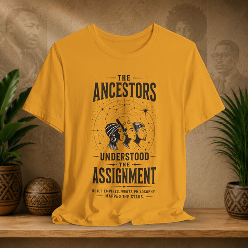 Yellow t-shirt with ancestors graphic on a wooden shelf with plants and decorative items.