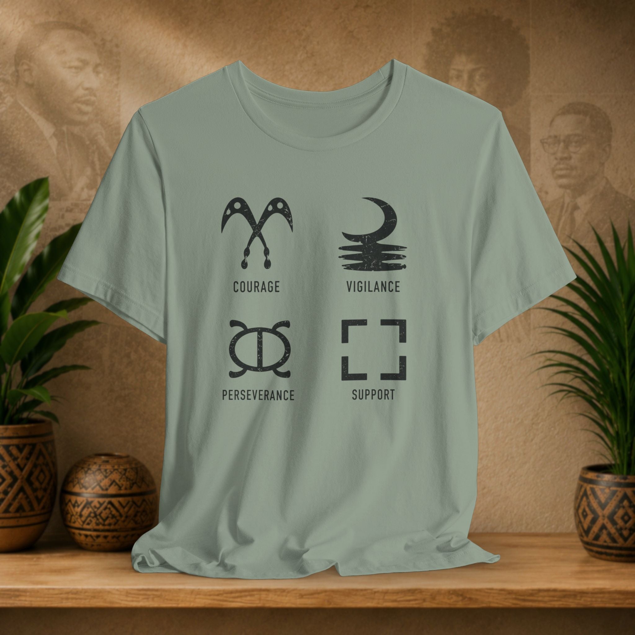 Light green t-shirt with symbols and text on a wooden surface with plants and a textured wall background