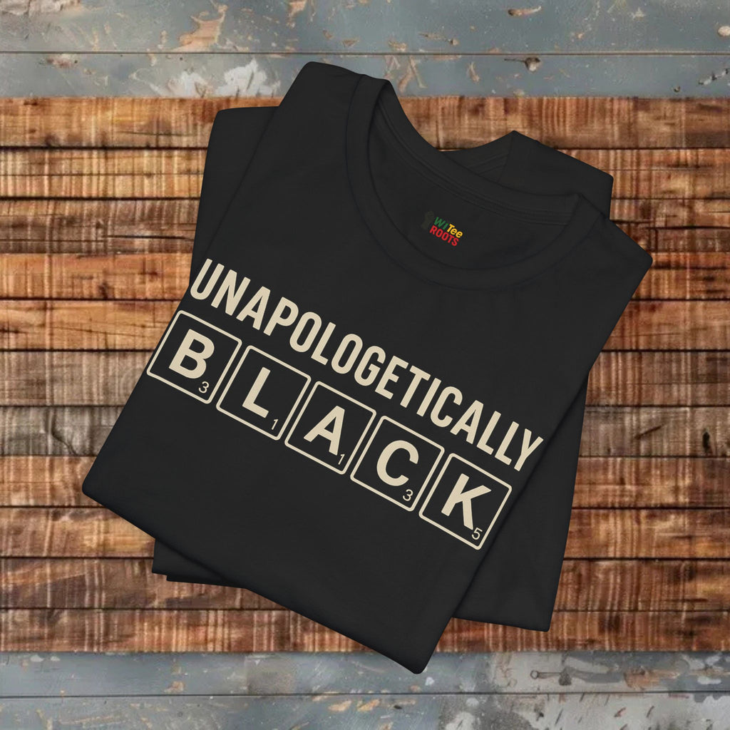 Black t-shirt with 'UNAPOLOGETICALLY BLACK' text on a wooden surface