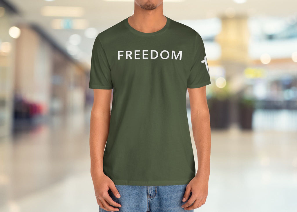Person wearing a green 'FREEDOM' t-shirt in a blurred indoor setting