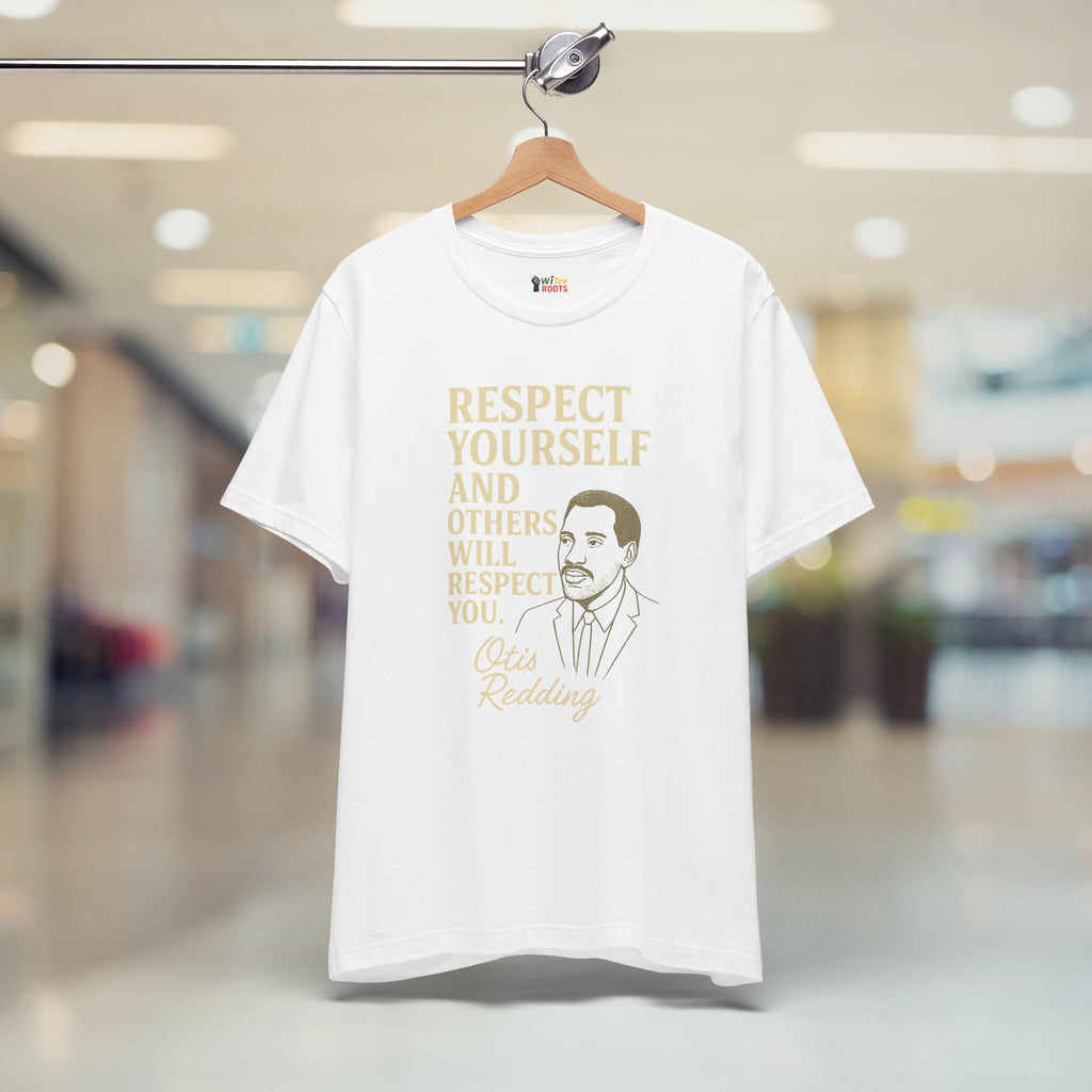 White t-shirt with gold text and a graphic of a man on a hanger in a store.