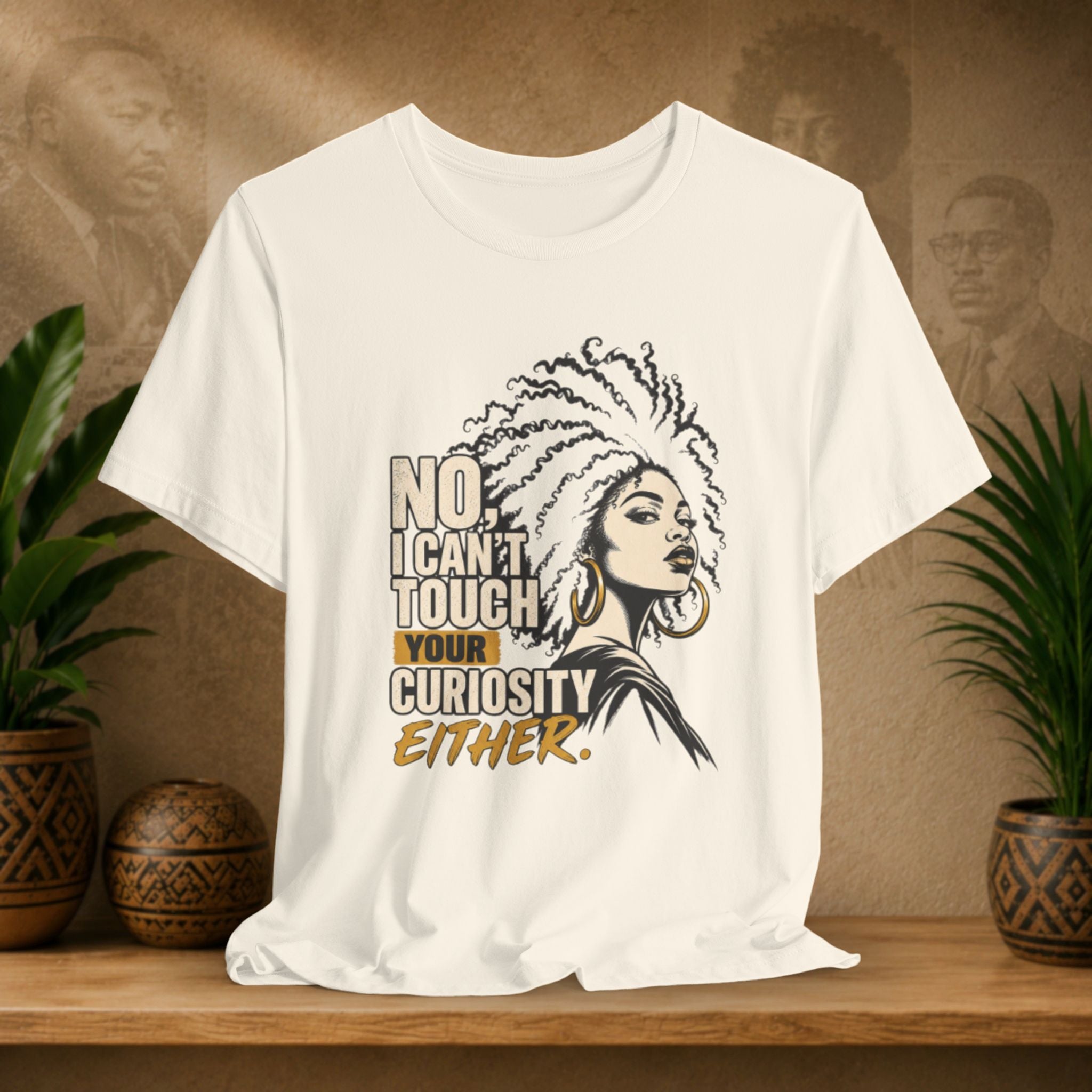 A off-white graphic t-shirt displayed on a wooden shelf, flanked by potted plants. The shirt features a black and gold graphic of a woman with an afro and the text 'NO.
