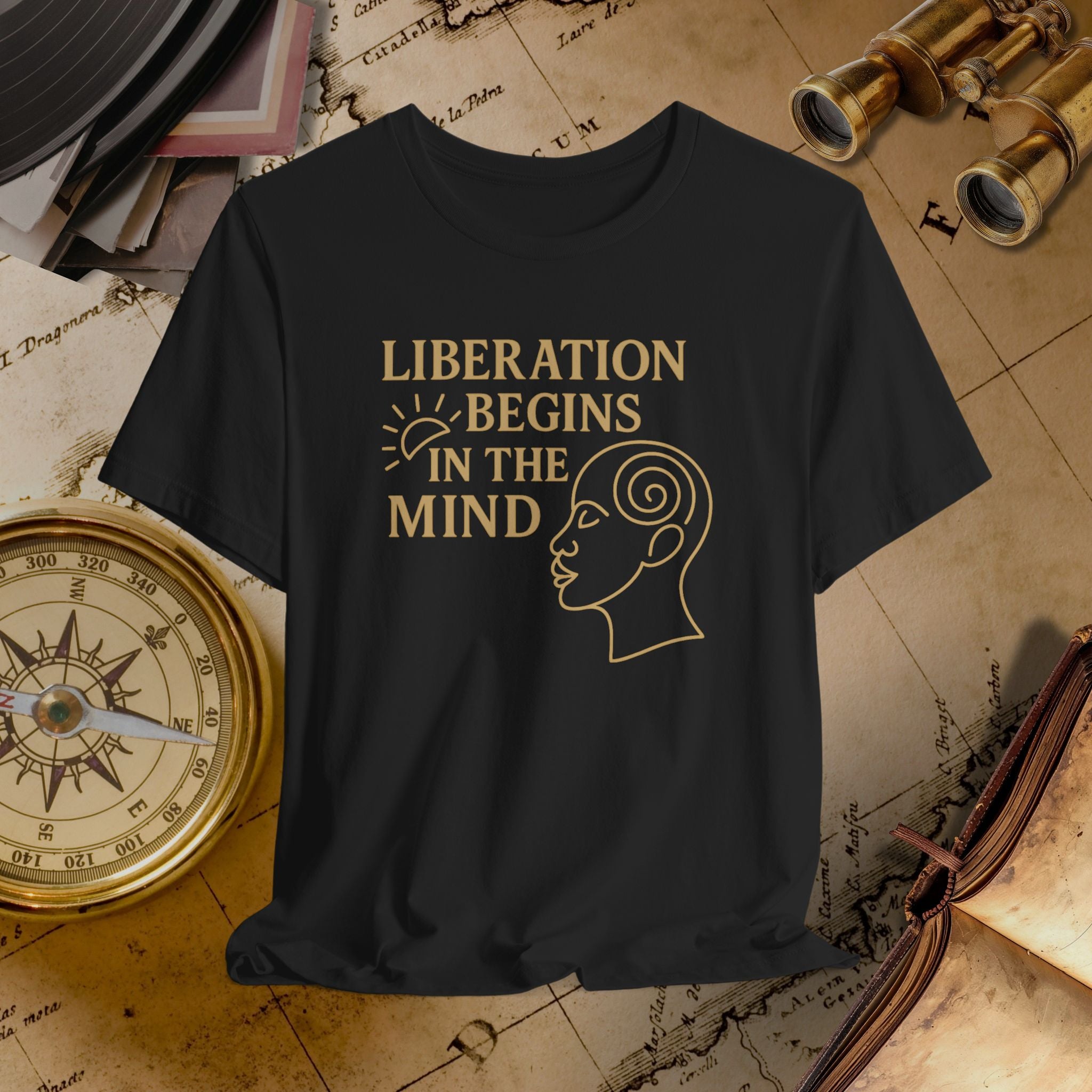 Black t-shirt with 'Liberation Begins in the Mind' text and graphic on a vintage map background.