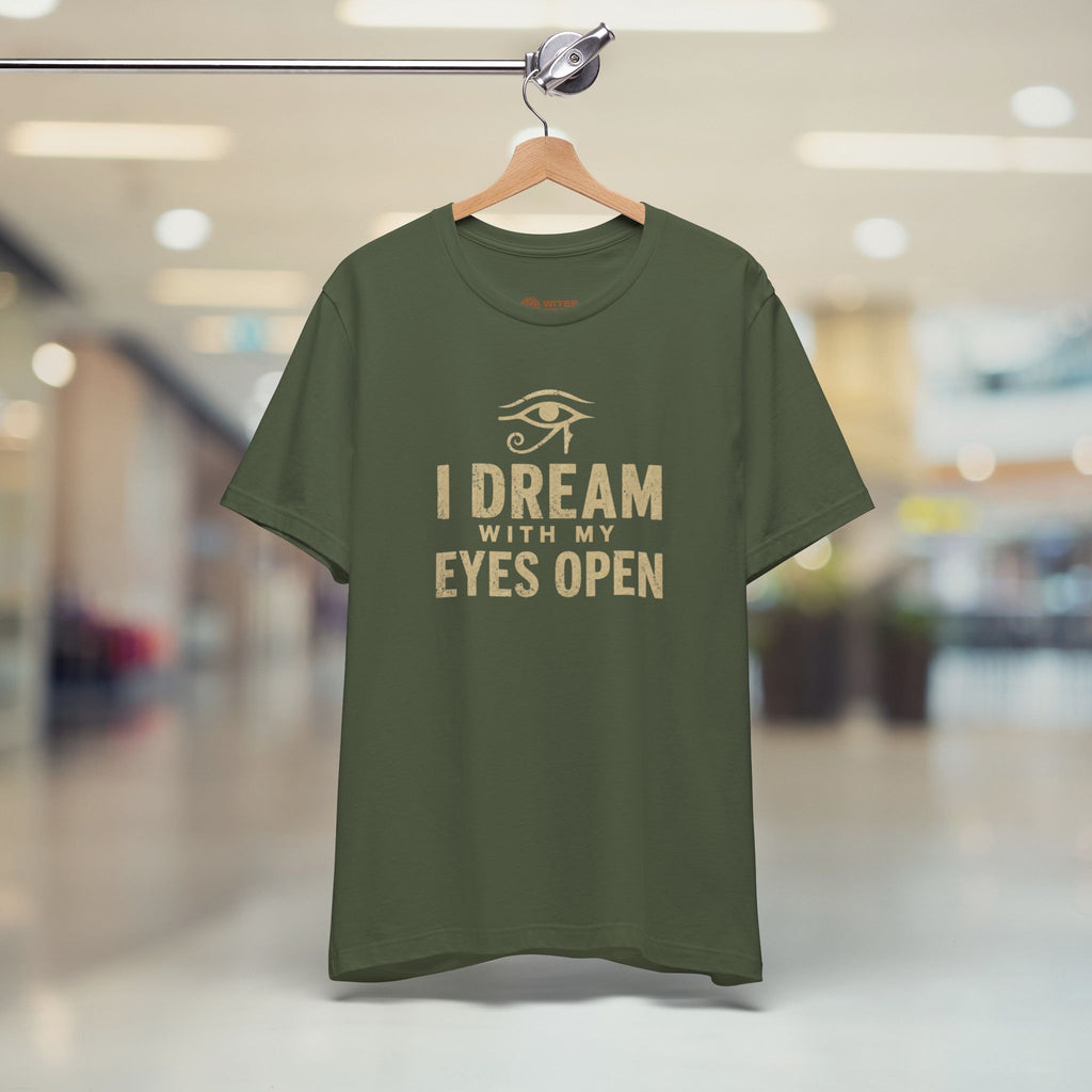 Green t-shirt with 'I Dream with My Eyes Open' text on a hanger in a store.