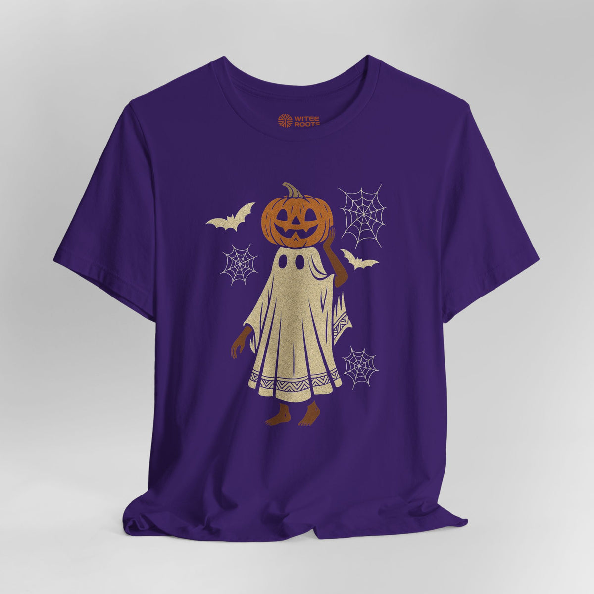A purple short-sleeve t-shirt with a Halloween graphic of a ghost character wearing a jack-o'-lantern head, surrounded by bats, spiderwebs, and a small orange Boo Night logo printed inside the collar, shown on a neutral gray background.