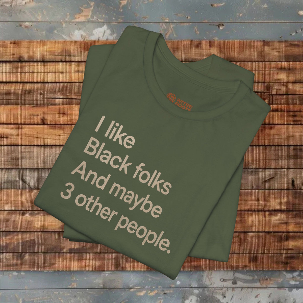 A military green graphic t-shirt with the text 'I like Black folks And maybe 3 other people.' printed in a light beige sans-serif font.