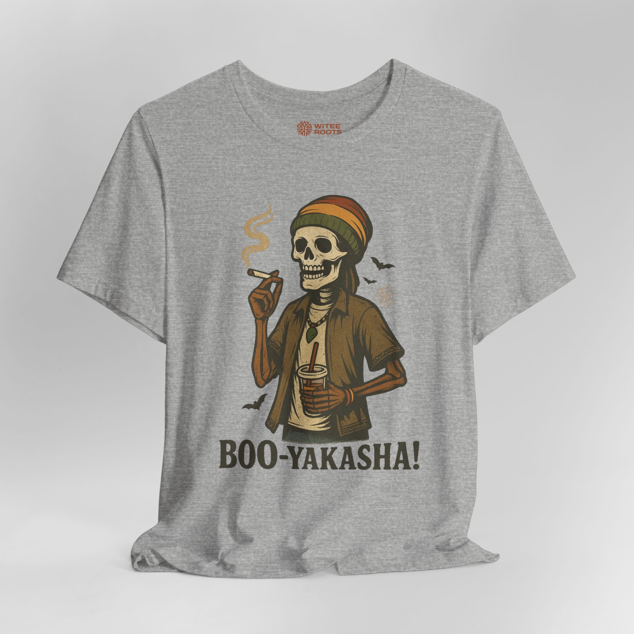 A heather gray short-sleeve t-shirt with a graphic of a cartoon skeleton wearing a Rasta hat and holding a drink and a cigarette. The text 'BOO-YAKASHA!' is printed below the graphic.