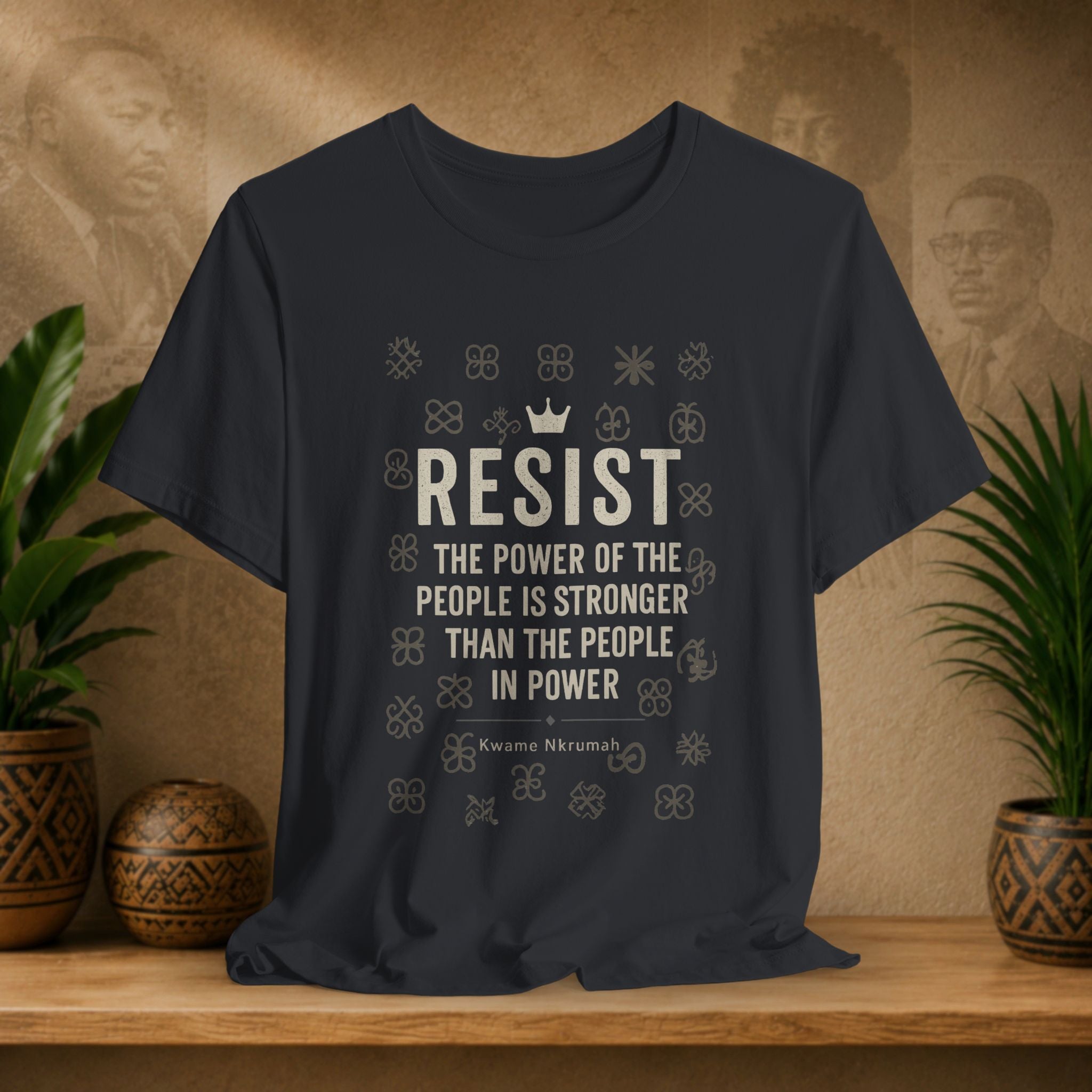 Black t-shirt with motivational quote on a wooden surface with plants and decorative items in the background