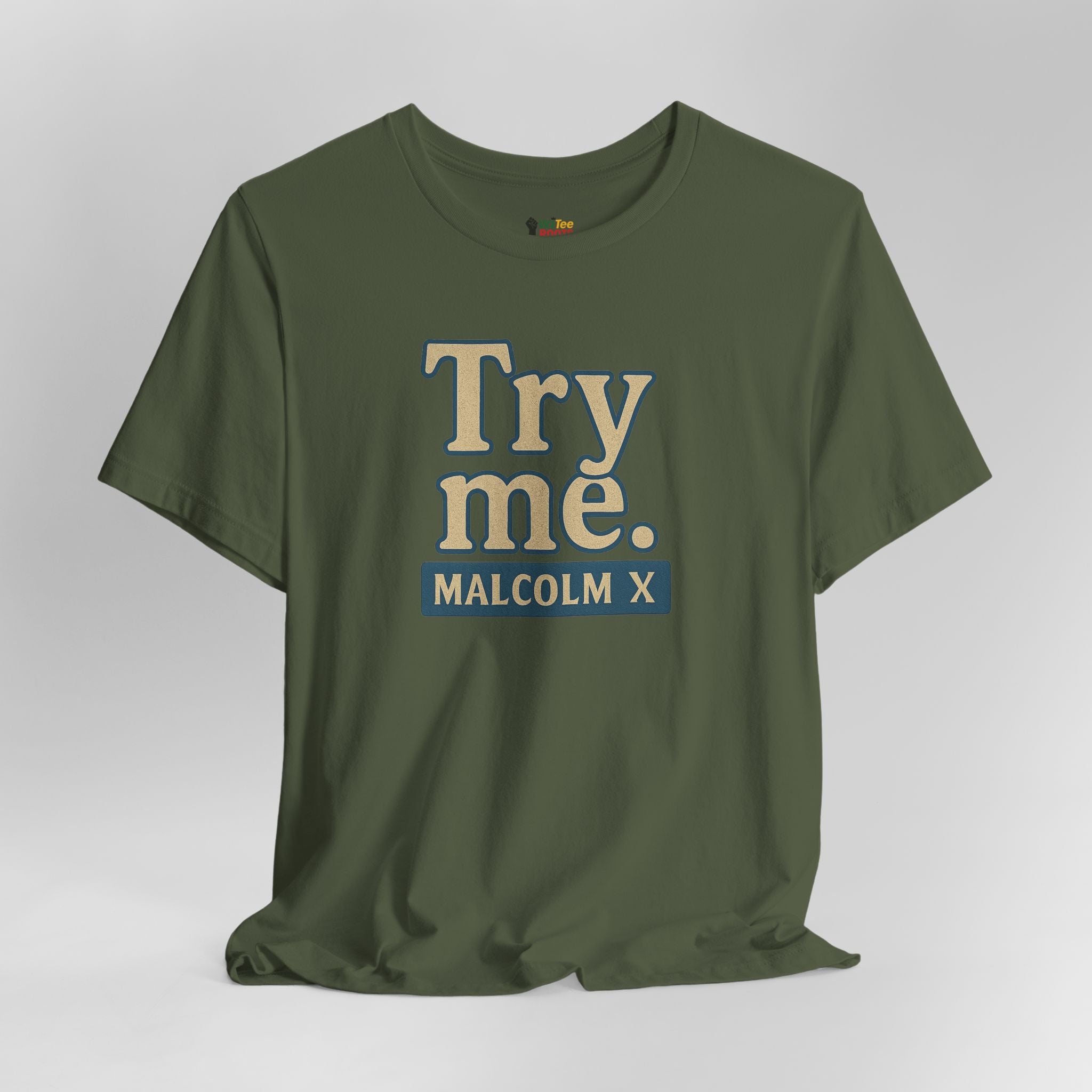 Green t-shirt with 'Try me. MALCOLM X' text on a gray background