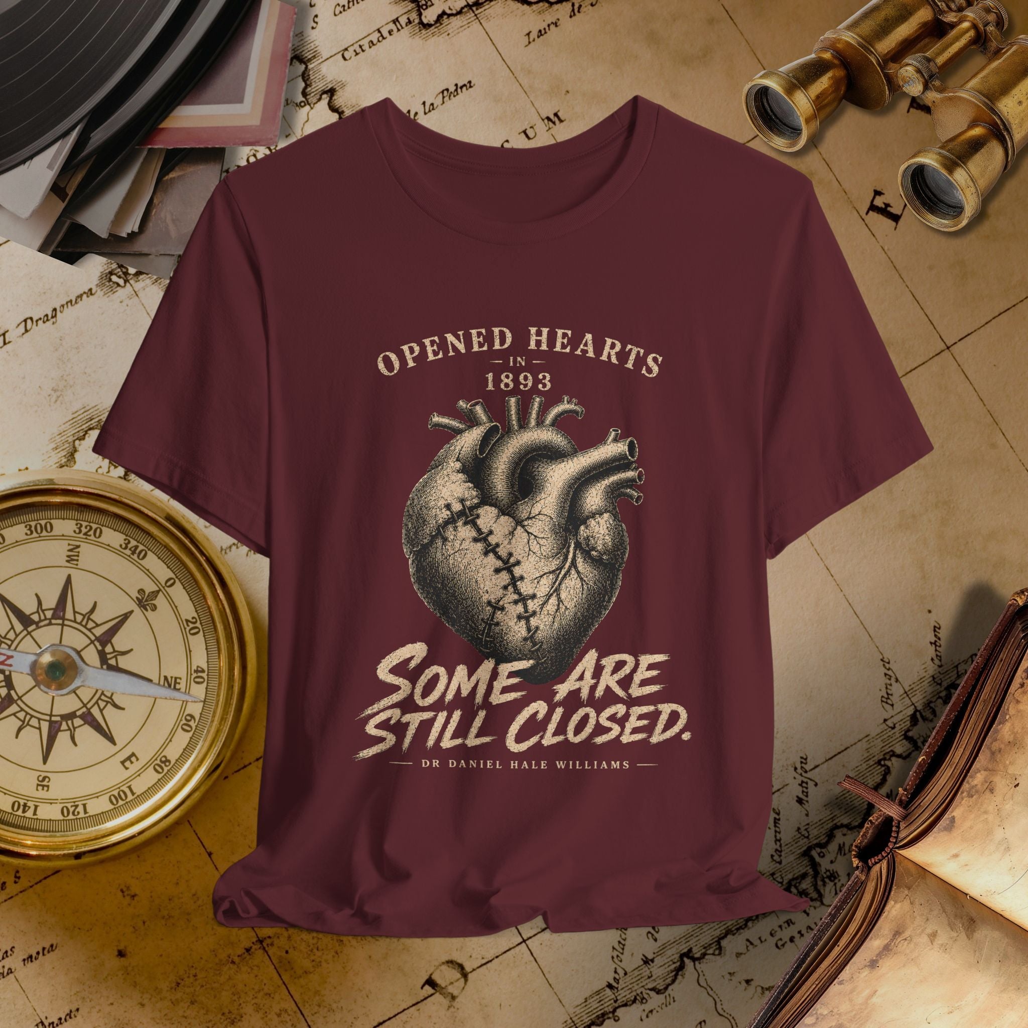 Maroon t-shirt with heart design and text on a vintage map background