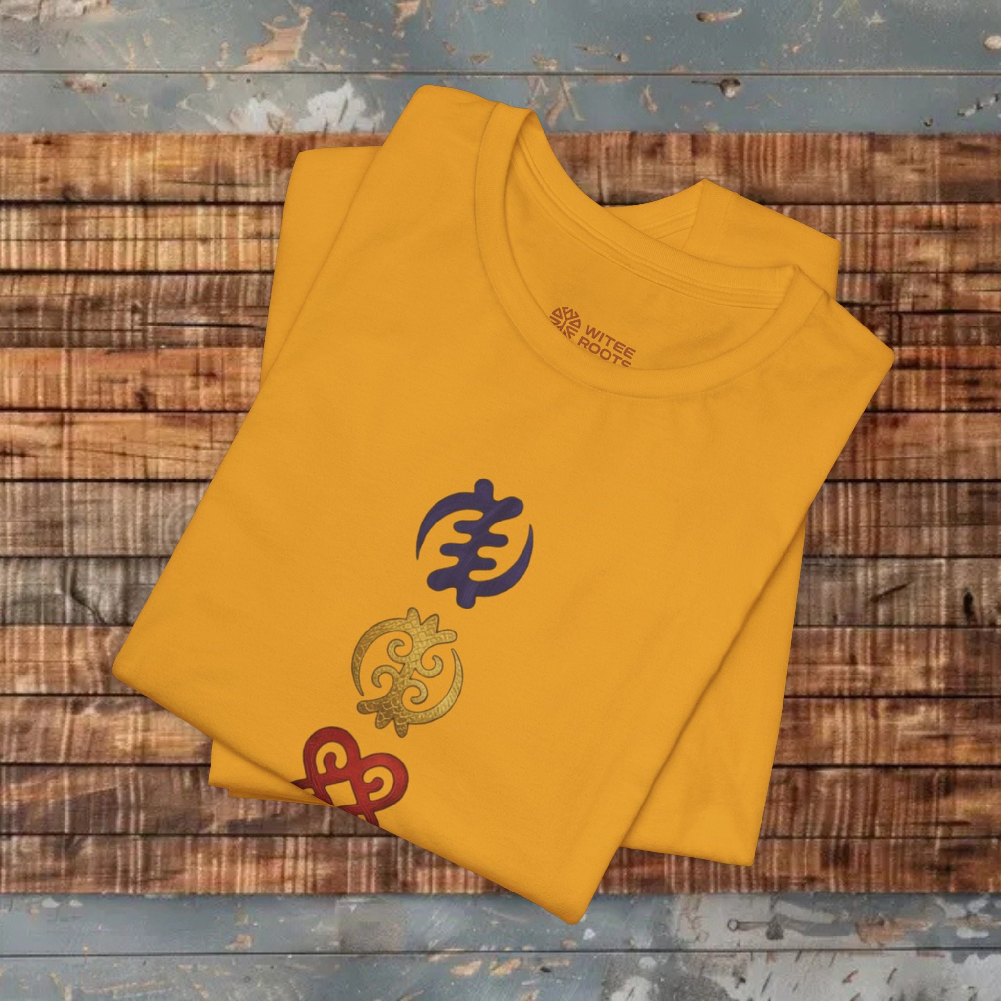 Mustard Tshirt with embroidered designs on a wooden surface