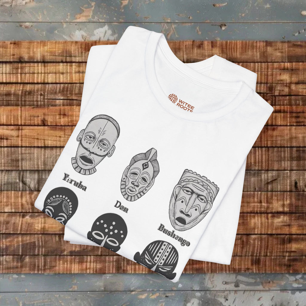 White t-shirt with black tribal mask designs on a wooden surface