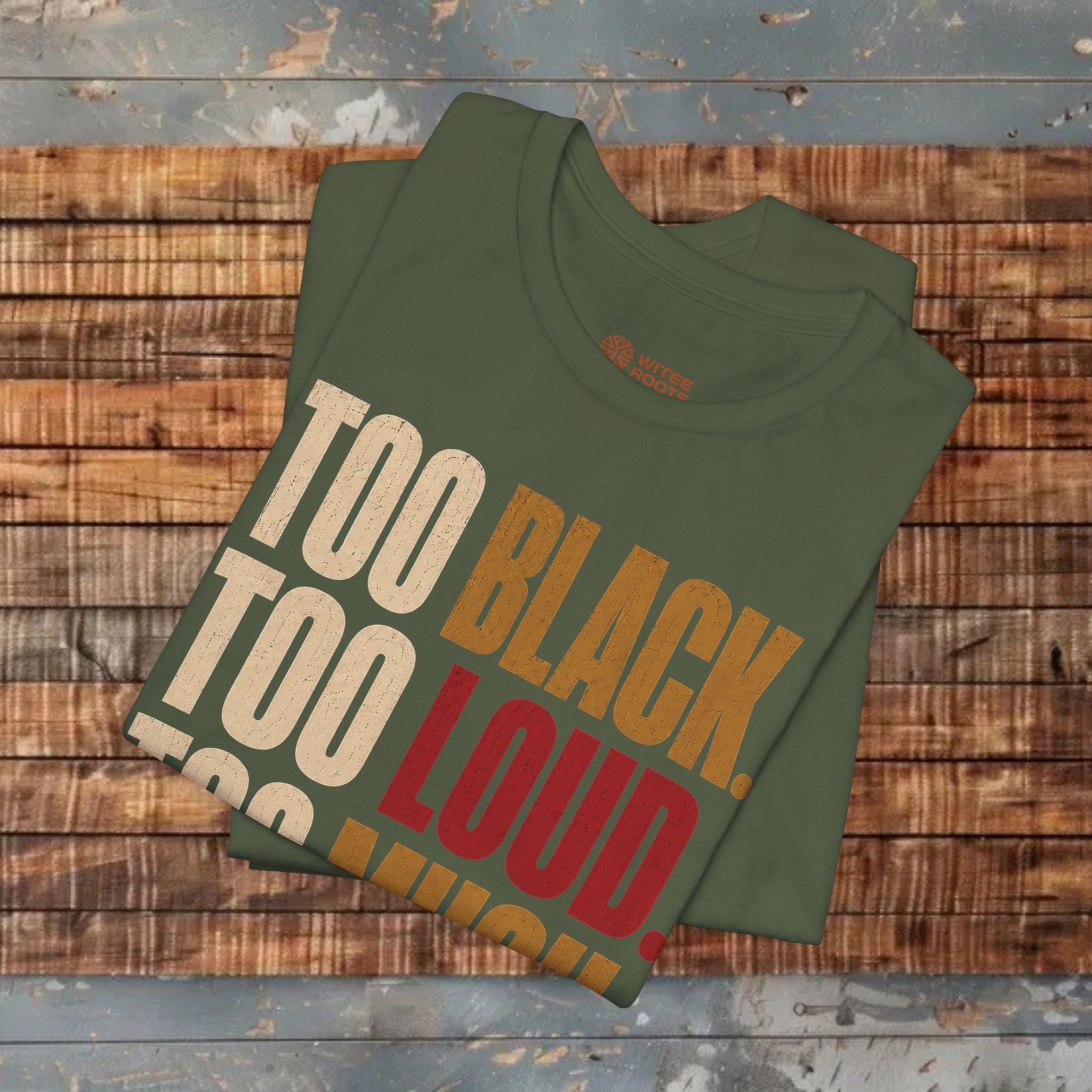 A folded olive green t-shirt with a graphic print reading 'TOO BLACK. TOO LOUD.