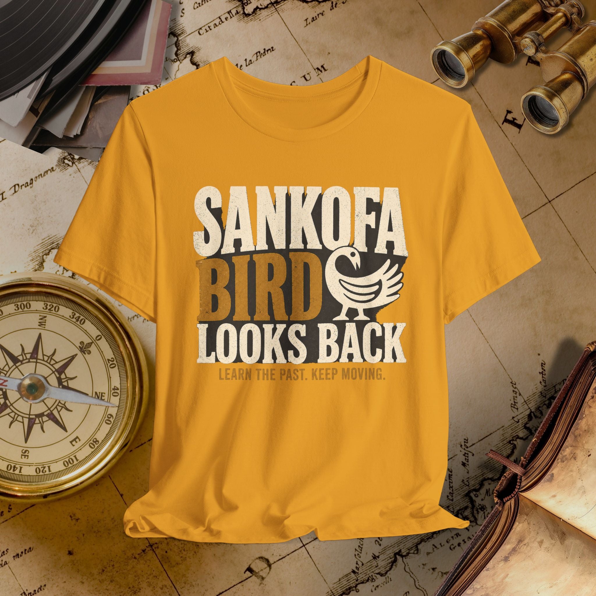 Mustard t-shirt with 'SANKOFA BIRD' text on a vintage map background