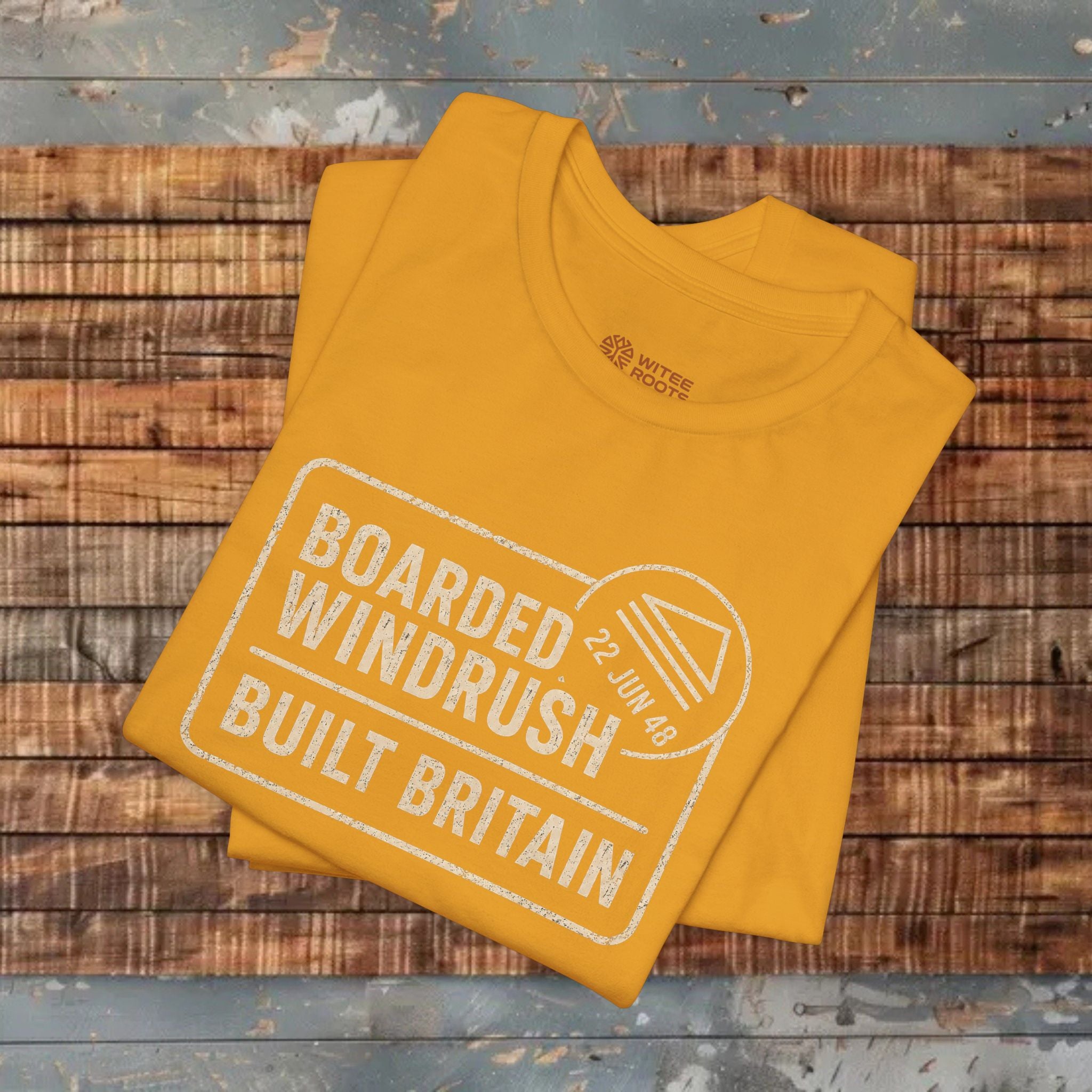 mustard t-shirt with text on a wooden surface