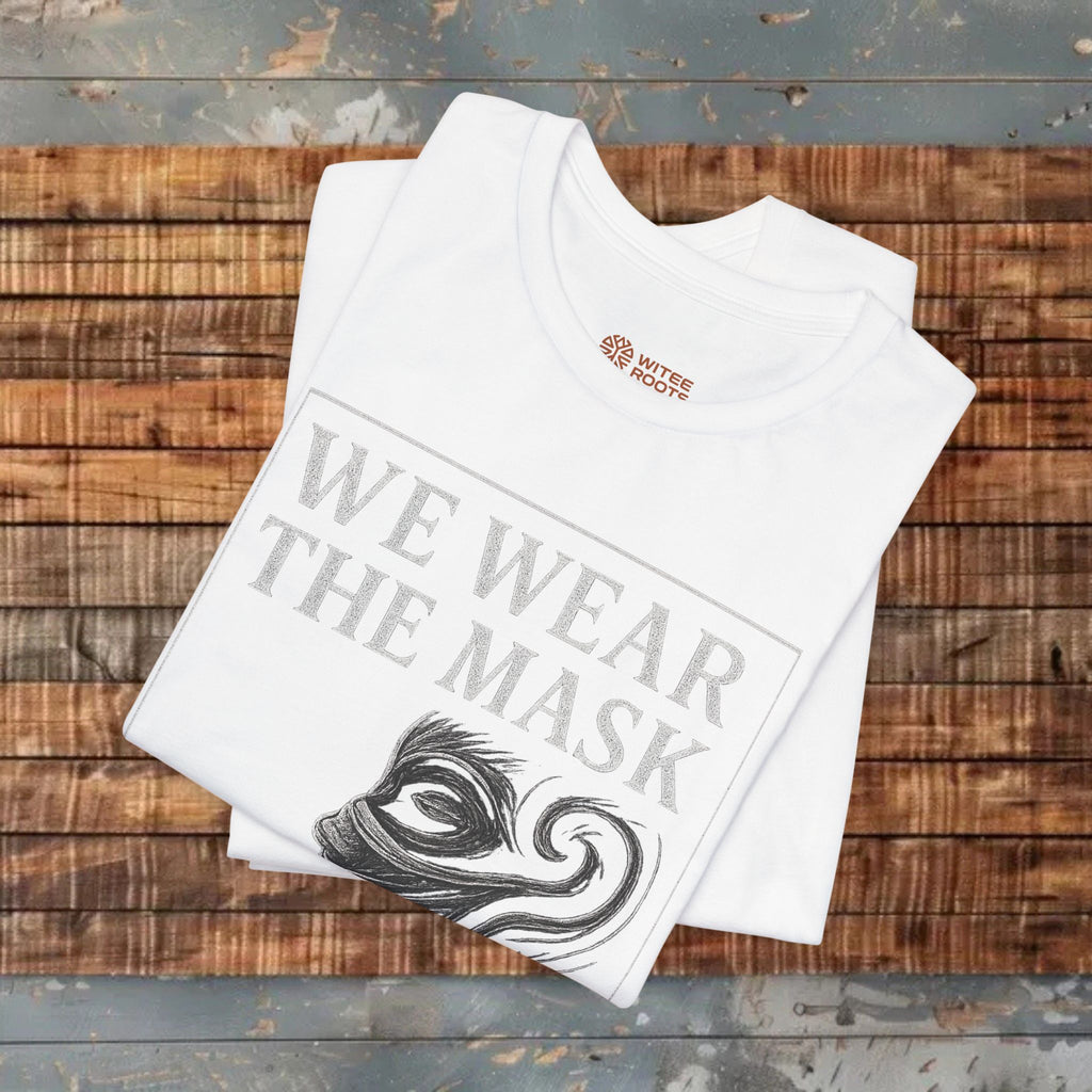 White t-shirt with 'WE WEAR THE MASK' text and logo on a wooden surface