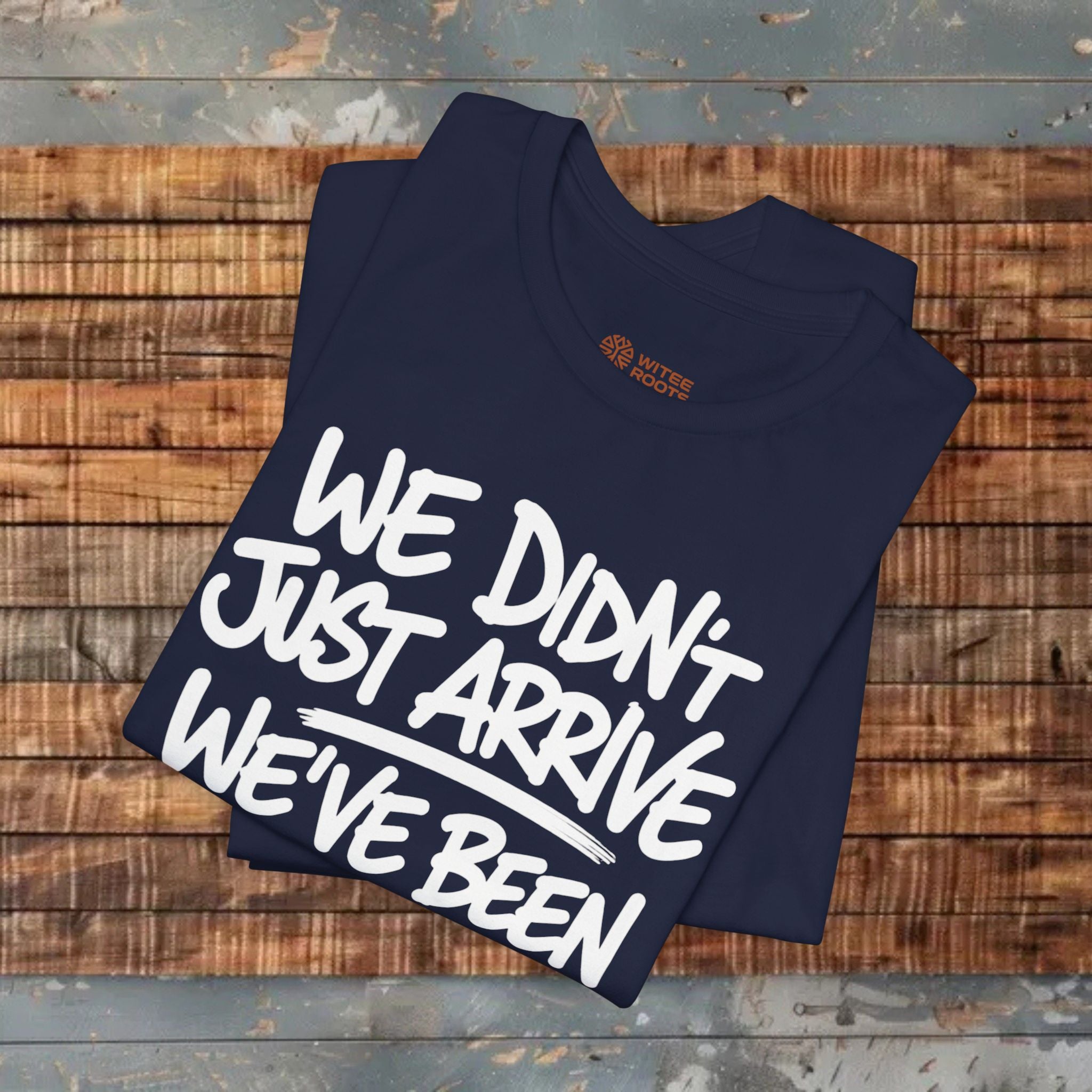 Folded navy blue t-shirt with white text on a wooden surface
