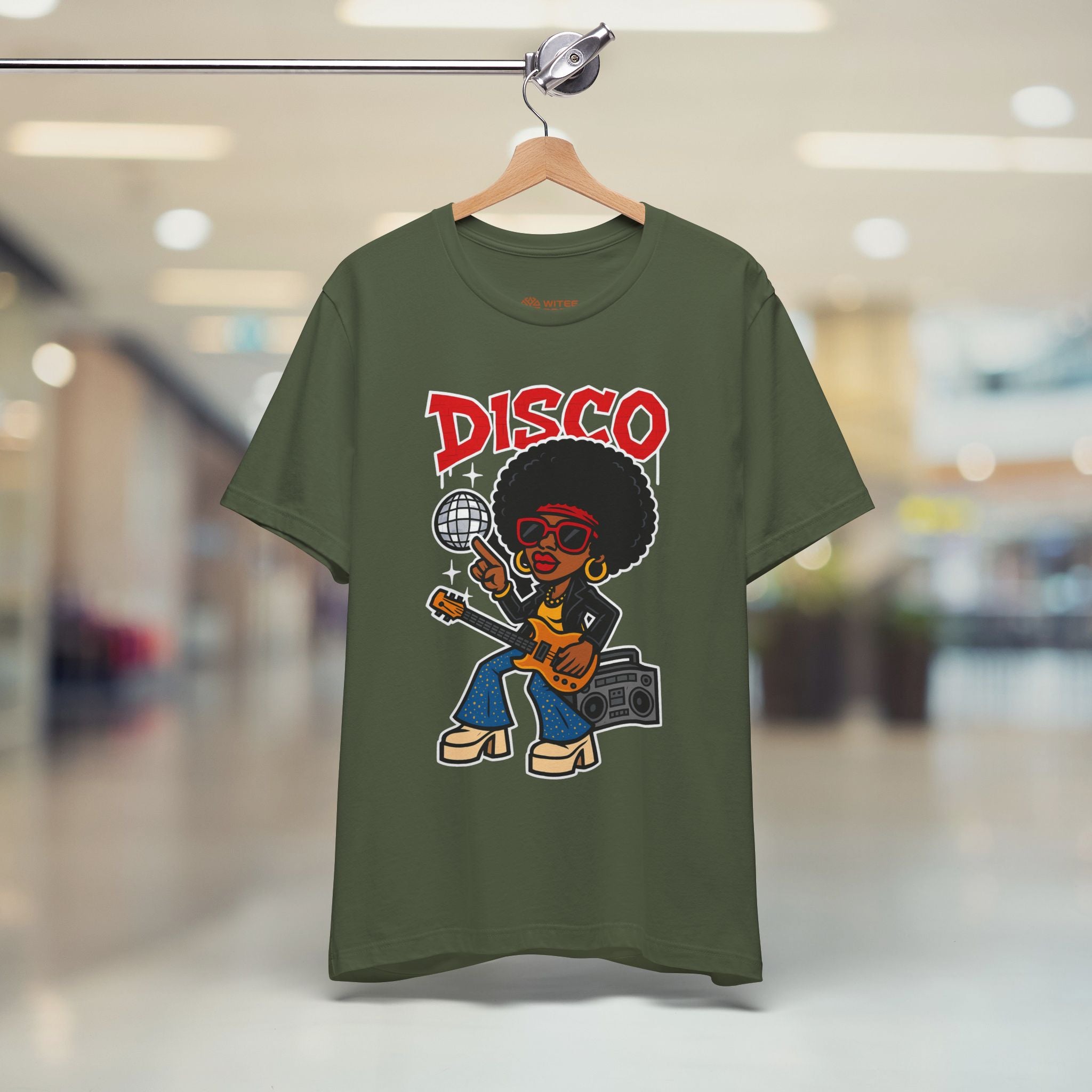 Green t-shirt with a disco-themed design on a hanger in a store setting