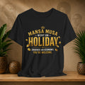 Black t-shirt with gold text on a wooden surface with plants and a textured wall background