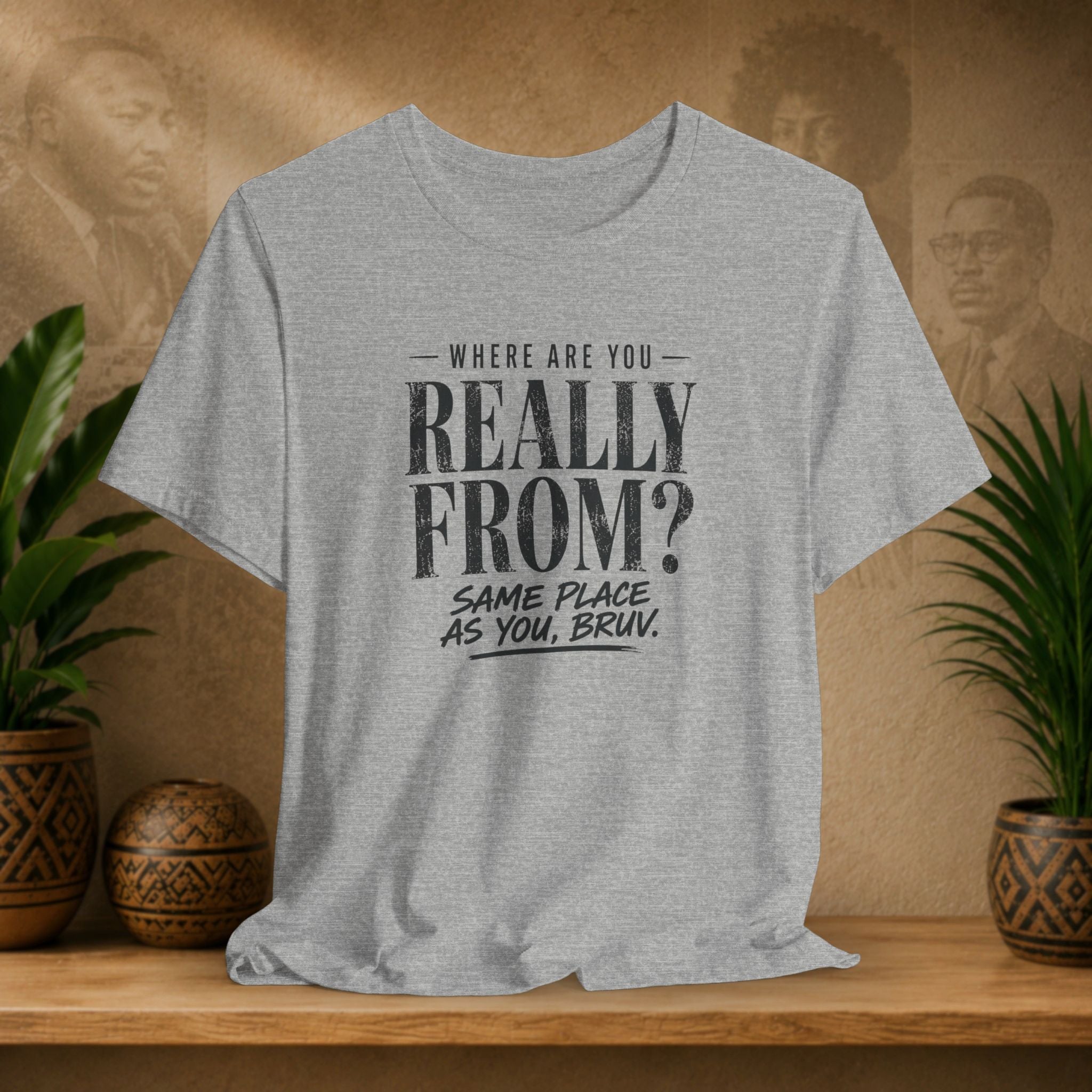 Gray t-shirt with humorous text design on a wooden surface with plants and a blurred background