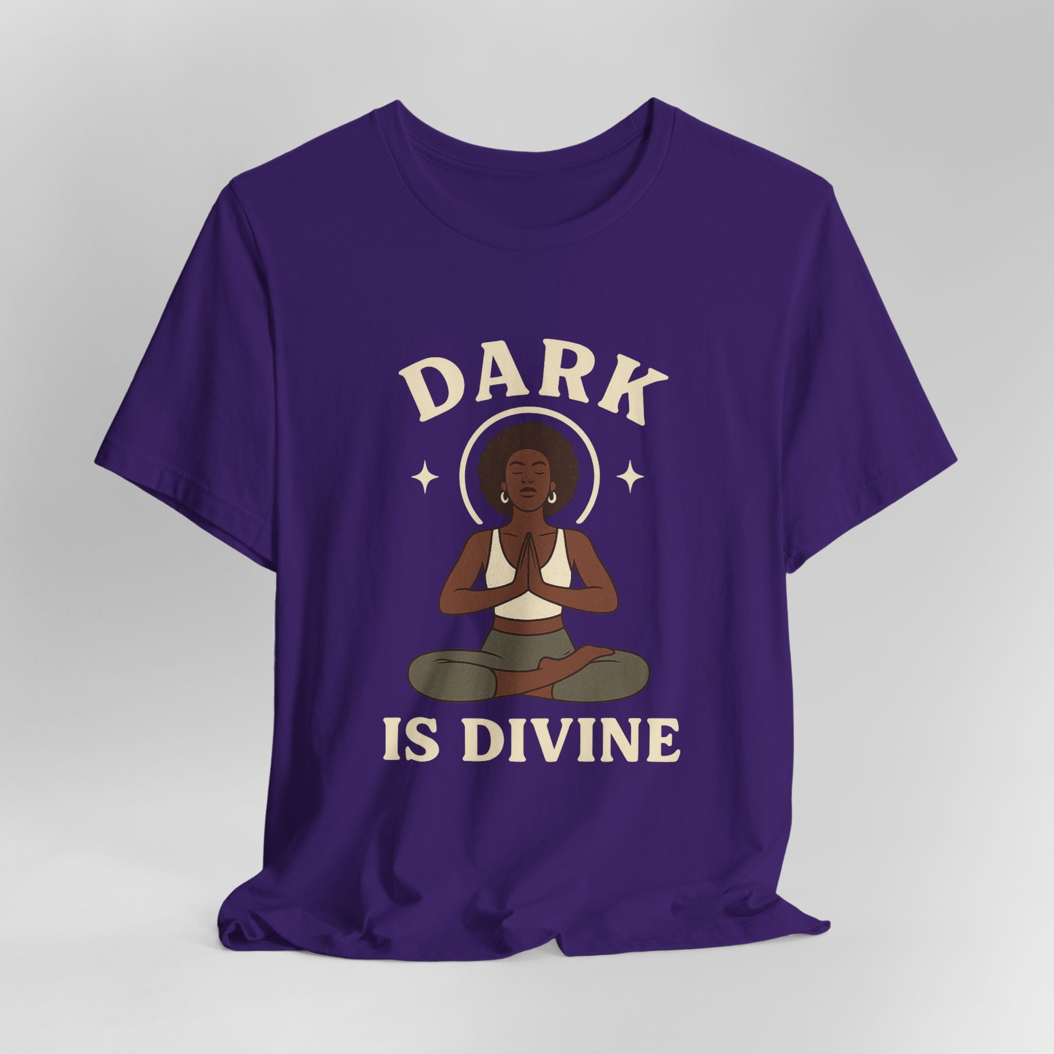 Purple t-shirt with a graphic of a woman meditating and 'Dark is Divine' text on a gray background
