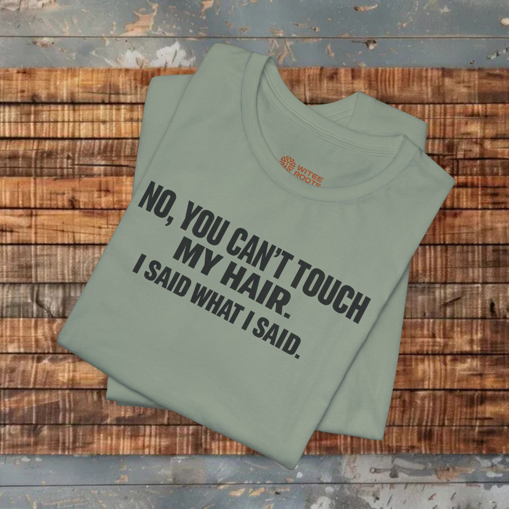 Folded green t-shirt with text on a wooden surface