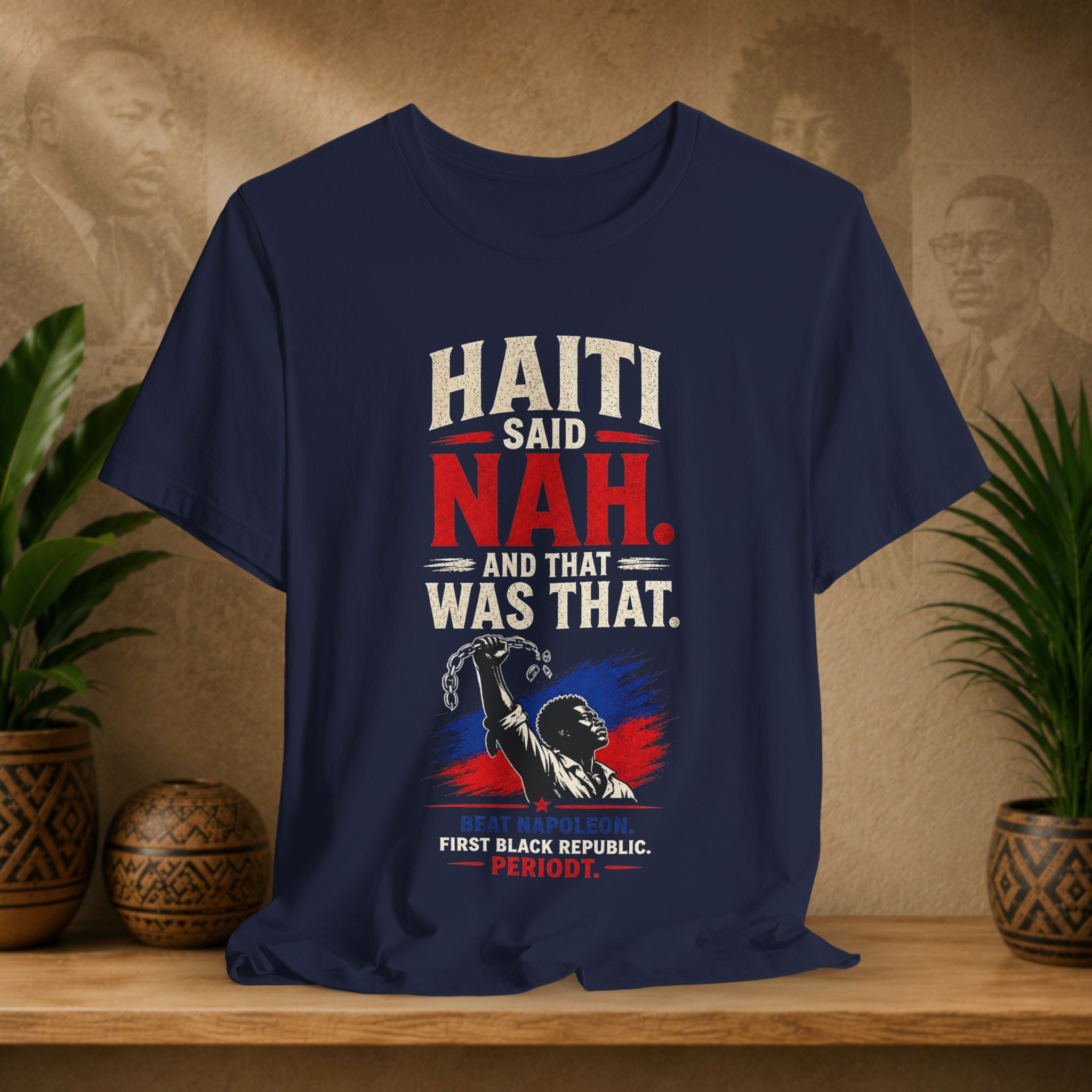 Navy blue t-shirt with political graphic and text on a wooden surface with plants and decorative items.