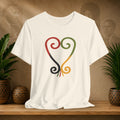 Beige t-shirt with a colorful abstract design on a wooden surface with plants and a textured wall background