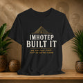 Black t-shirt with 'IMHOTEP BUILT IT' text on a wooden surface with decorative items.