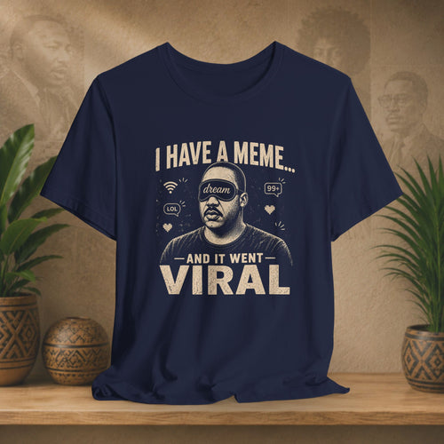 Navy blue t-shirt with graphic design and text on a wooden surface with plants in the background